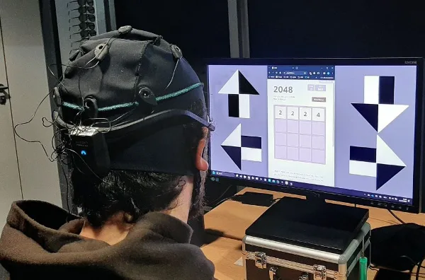 A user wearing an EEG headset plays 2048 through flickering on-screen stimuli